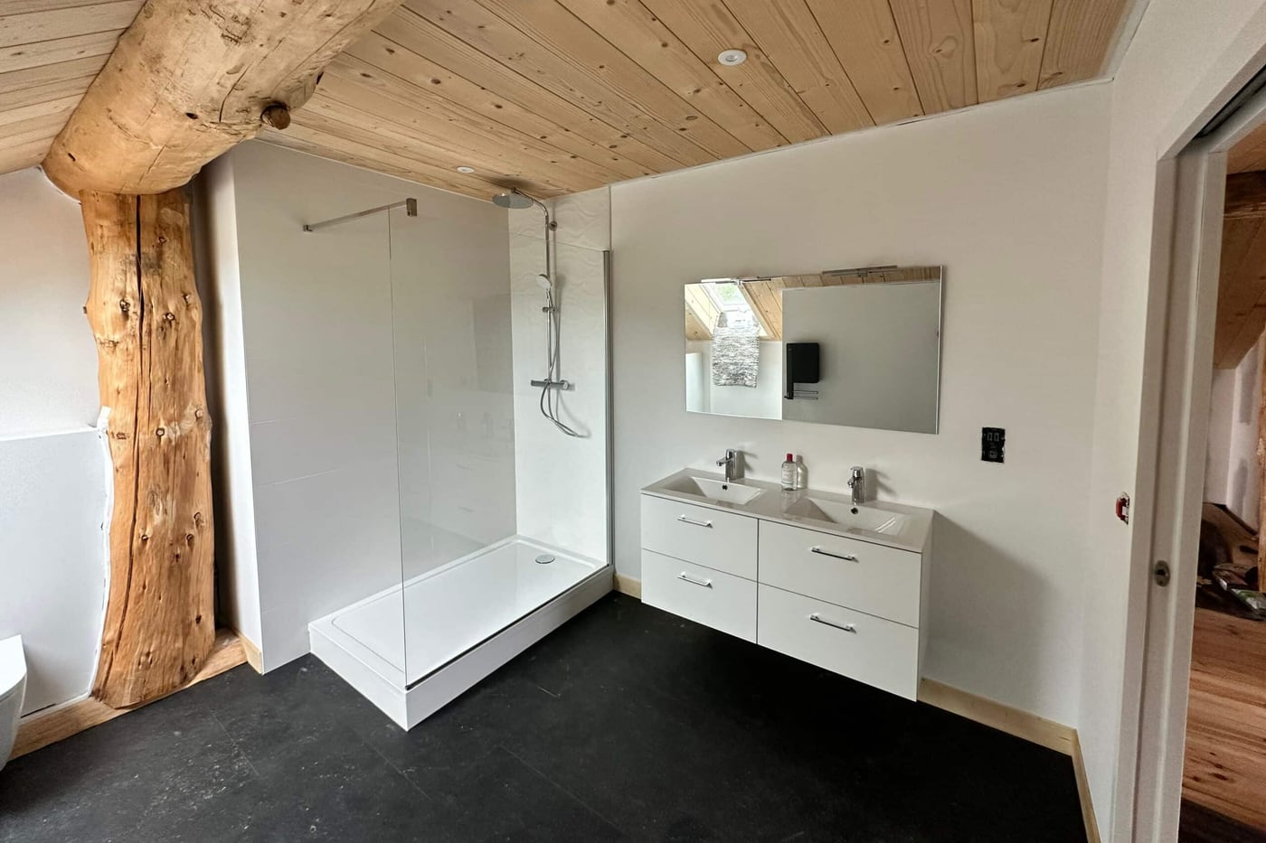Salle d'eau rénovée sous charpente bois, douche à l'italienne et meuble double vasque